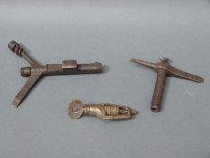 Two Enfield combination multi-tools together with a brass drilling tool