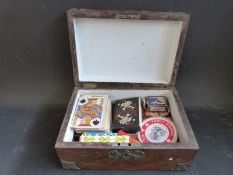 A vintage wooden box with brass decoration containing a collection of playing cards including 19th