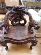 A late 19th/20thC intricately carved Chinese/Asian chair with dragon handles and legs