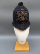 A vintage City of London police helmet with D66 helmet badge
