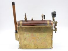 A horizontal live steam boiler clad in wood with whistle, safety valve,