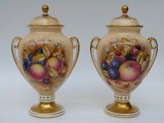A pair of Aynsley Orchard Gold lidded urns, signed D.