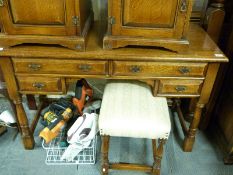 An oak dressing table or desk fitted four drawers and similar stool (H76 x W122 x D52cm)