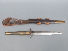 A 2nd pattern Fairbairn Sykes fighting knife with knurled grip in leather sheath