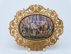 A miniature porcelain plaque in pierced yellow metal frame (length 10cm overall)