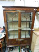 An inlaid Edwardian cabinet with painted swags and ribbons decoration raised on tapering legs and