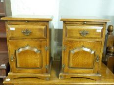 A pair of oak bedside cabinets with brushing slide,