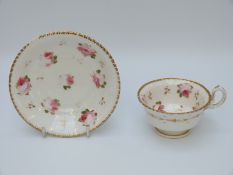 An early 19th century porcelain cup and saucer decorated with flowers,