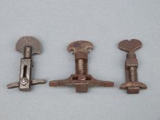 Three flintlock gun mainspring clamps, one with pierced grip.