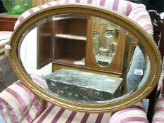 An oval mirror with bevelled glass (83cm tall)