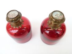 A pair of cranberry glass scent bottles with engraved gilt metal mounts,