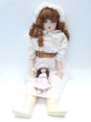 Two Lilian Middleton bisque headed dolls, one with closed mouth, fixed blue eyes, curled brown hair,