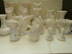 A large collection of Belleek including owl vase, five pairs of vases,