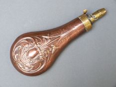 Sykes copper and brass powder flask with embossed flower and leaf decoration, 21cm long.