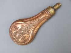 Copper and brass powder flask with embossed spiralling decoration,