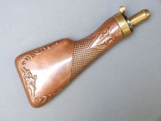 James Dixon & Sons copper and brass powder flask in the form of a gun stock with ornate scrolling