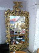 An ornate giltwood mirror with griffin finial (H140 x W60cm)