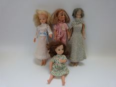 Four Sindy and similar dolls, all in different outfits,