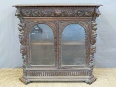 A Victorian carved oak glazed cabinet with shaped top drawer,