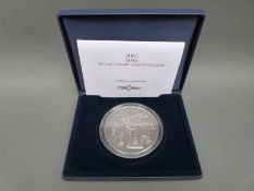 A 5oz silver 2003 annual history commemorative coin depicting various anniversaries,
