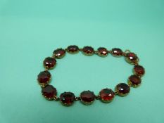 A Victorian bracelet set with oval garnets