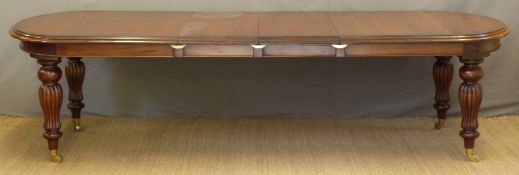 A Victorian style reproduction extending dining table raised on brass castors, length min 211,