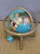 A pietra dura globe on brass stand with compass below,