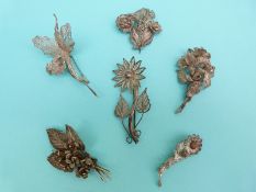 Six white metal filigree brooches, all in the form of flowers,