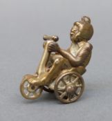 A novelty cigar cutter in the form of a monkey riding a bike,