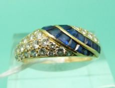 An yellow metal ring set with baguette cut sapphires and round cut diamonds (Size N)