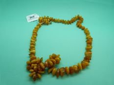 An amber necklace made up of opaque/ translucent irregular shaped beads, 96g.