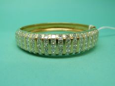 A Kutchinsky 18ct gold bangle set with eighteen rows of five princess cut diamonds in channel