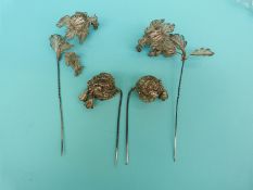 A pair of white metal filigree stick pins in the form of flowers with spring sections and a pair of