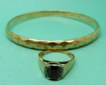 An 18ct gold ring set with a garnet and diamonds and a rolled gold flapper bangle