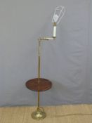 A brass library lamp with tray table and articulated arm,