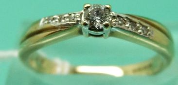 A 9ct gold ring set and a diamond solitaire with further diamonds to the shoulders (Size M)