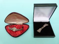 A silver and marcasite cocktail watch and a silver and marcasite bow brooch