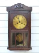 A circa 1910 mahogany cased two train wall clock with glass door panels and Arabic dial,
