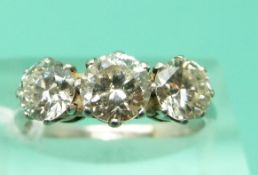 A platinum ring set with three round brilliant cut diamonds,