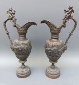 A pair of bronze neoclassical style urns with cherubs to handles,