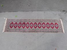 A wool runner with 12 guls in red octagons, 79x300cm.