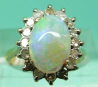 An 18ct gold ring set with an opal cabochon surrounded by diamonds (Size L)