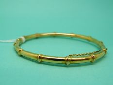 A yellow metal bangle in the form of bamboo,