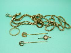 A 9ct gold horse shoe stick pin set with diamonds, a yellow metal wedding band,