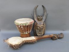 A four stringed African gourd type instrument with antelope/goat skin covering together with a drum