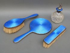A George V guilloche enamel and hallmarked silver dressing table set comprising hand mirror,