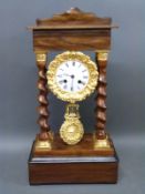 A 19th century French mantel clock supported on four barley twist columns,