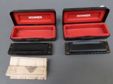 A cased Hohner 'Pro-Harp' harmonica in key of A together with a further example in C