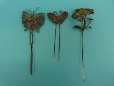 A silver gilt filigree stick pin in the form of a butterfly with spring section and two white metal