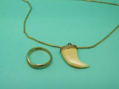 A 9ct gold ring and a 9ct gold pendant set with ivory in the shape of a tooth
